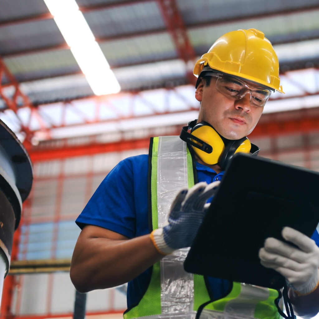 Ingenieur mit Tablet auf einer Baustelle, symbolisiert Bauüberwachung und technische Projektleitung